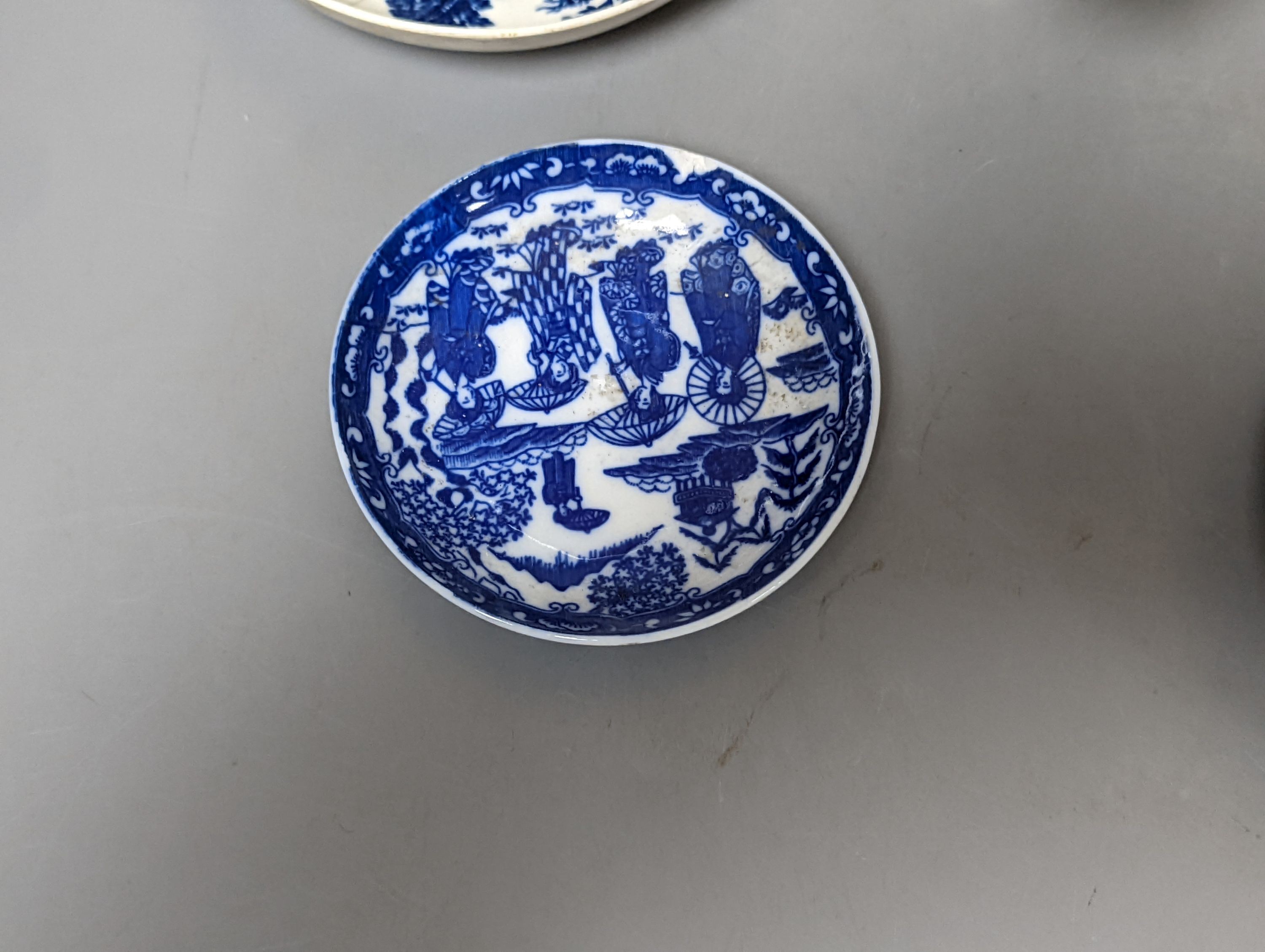 A Worcester blue and white sauceboat, two tea bowls and saucers, late 18th century and a Japanese single saucer. (7)